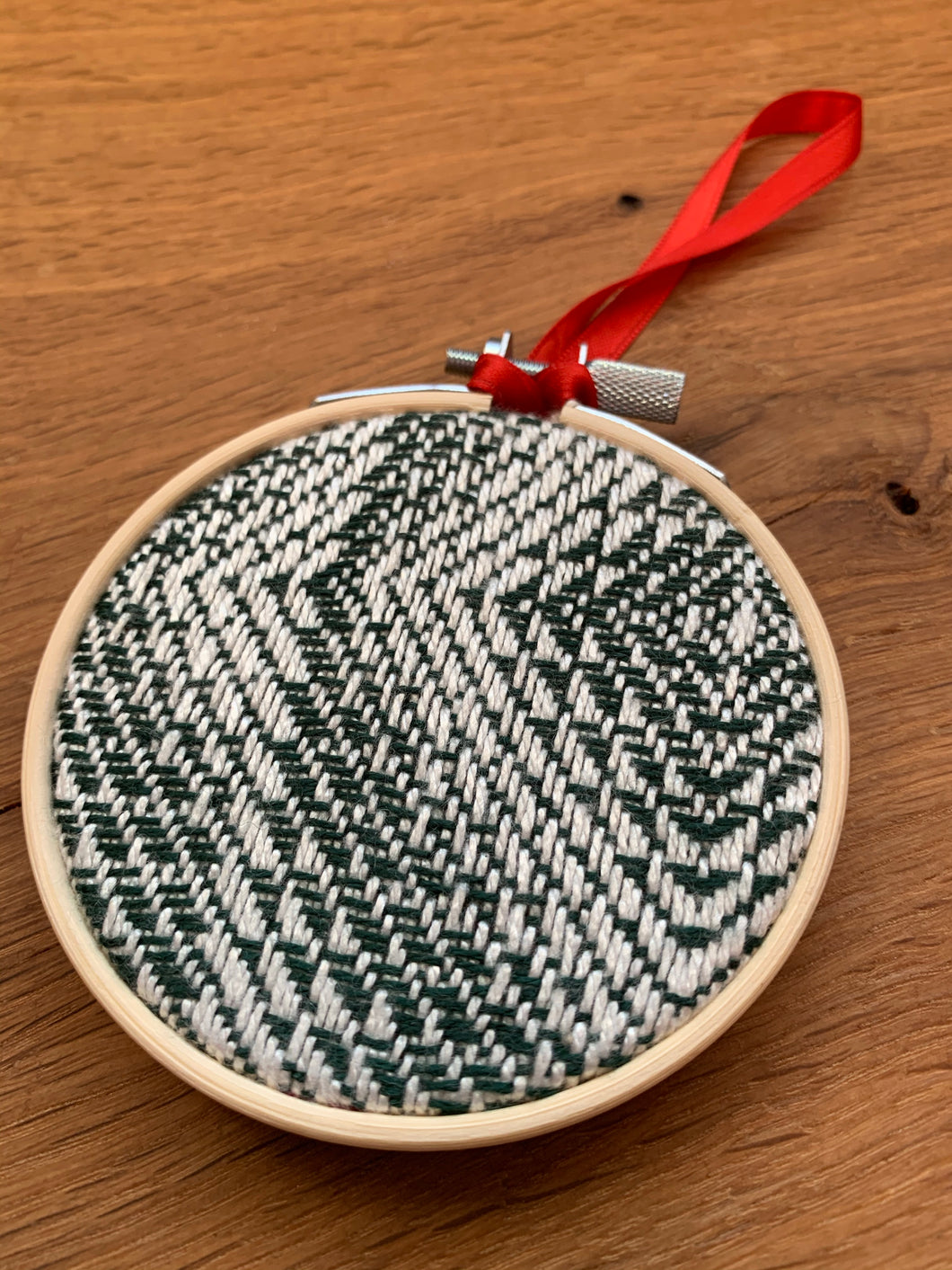green and white hand woven bamboo Christmas ornament  with a red ribbon